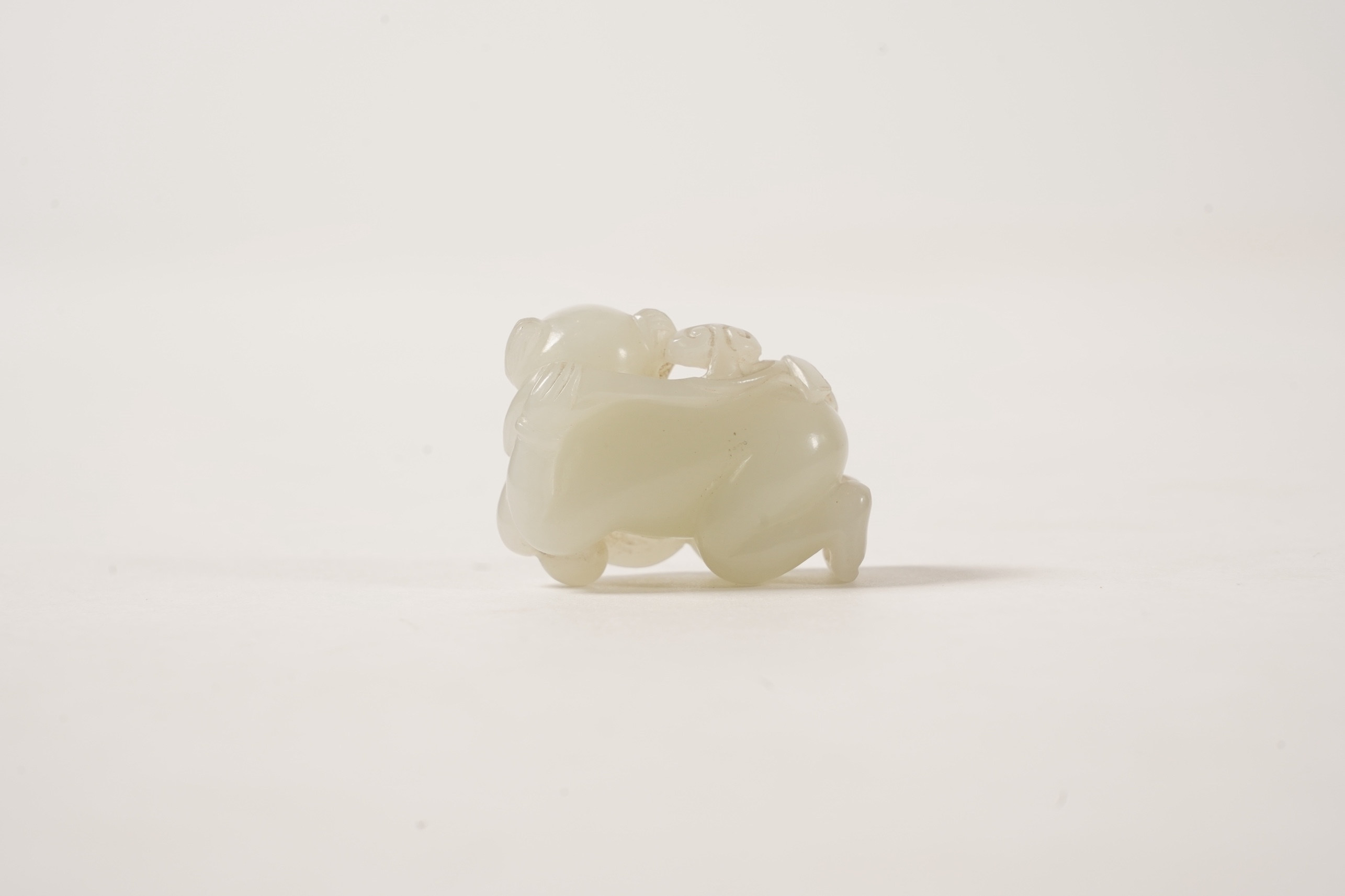 A Chinese white jade figure of a crouching boy, 19th/20th century